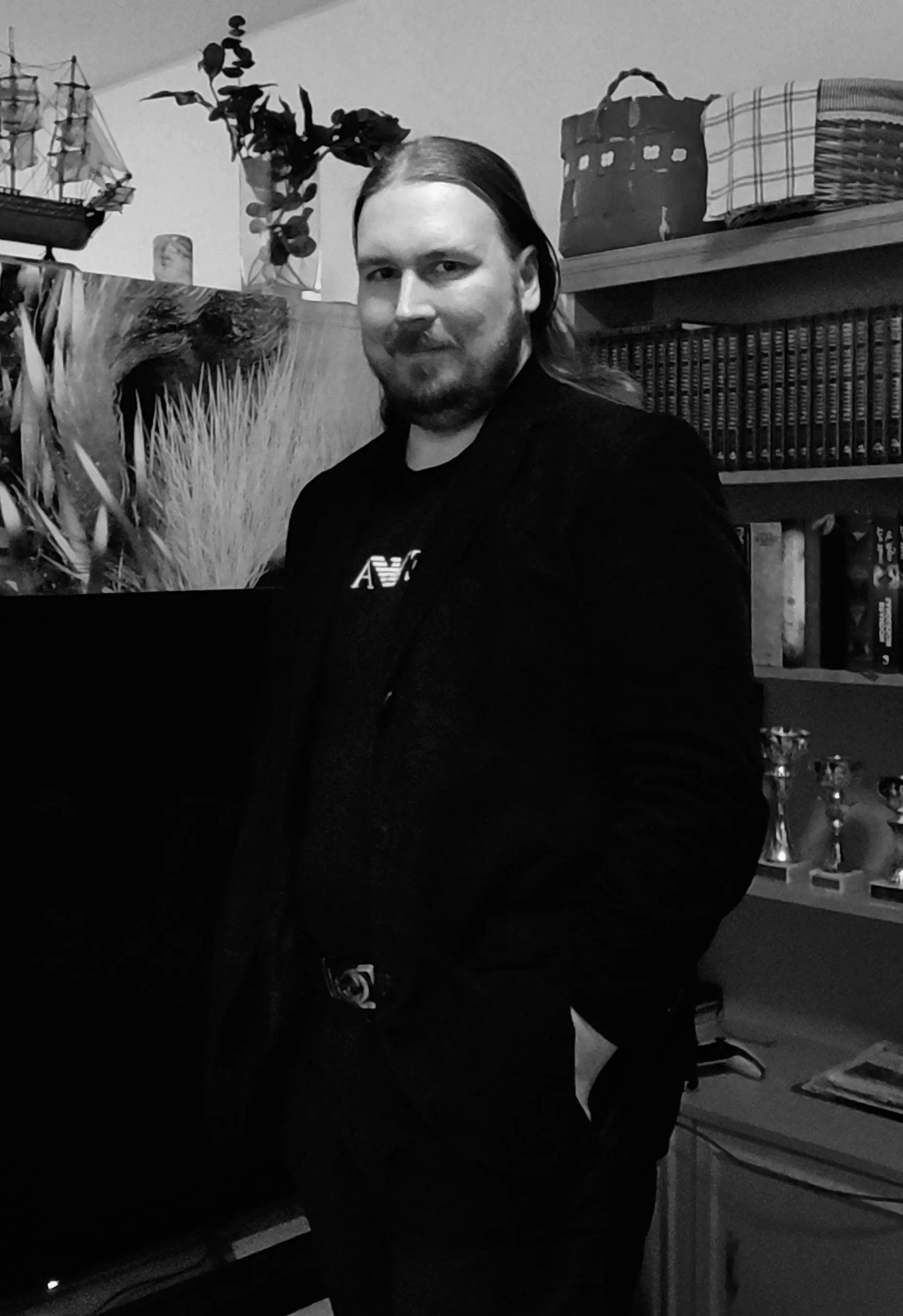 Site author who goes by the handle Tomkarho standing in front of a bookshelf at his home.